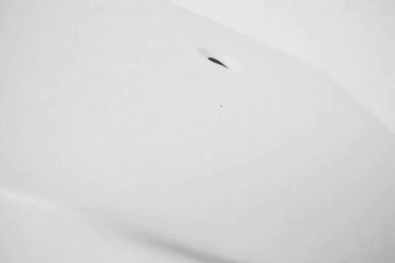 white surface with small black mark