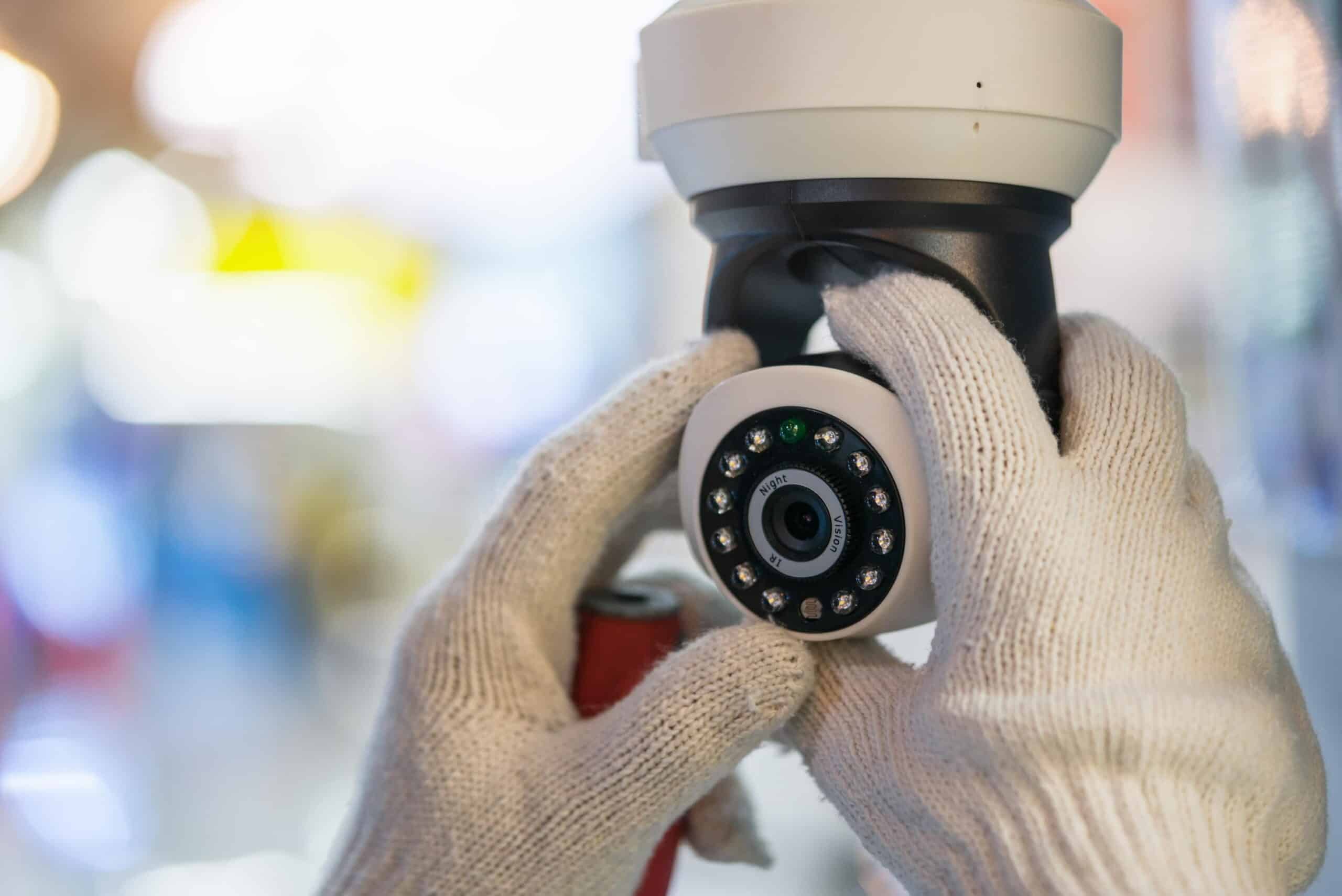 Technician installing a night vision CCTV security camera with IR LEDs