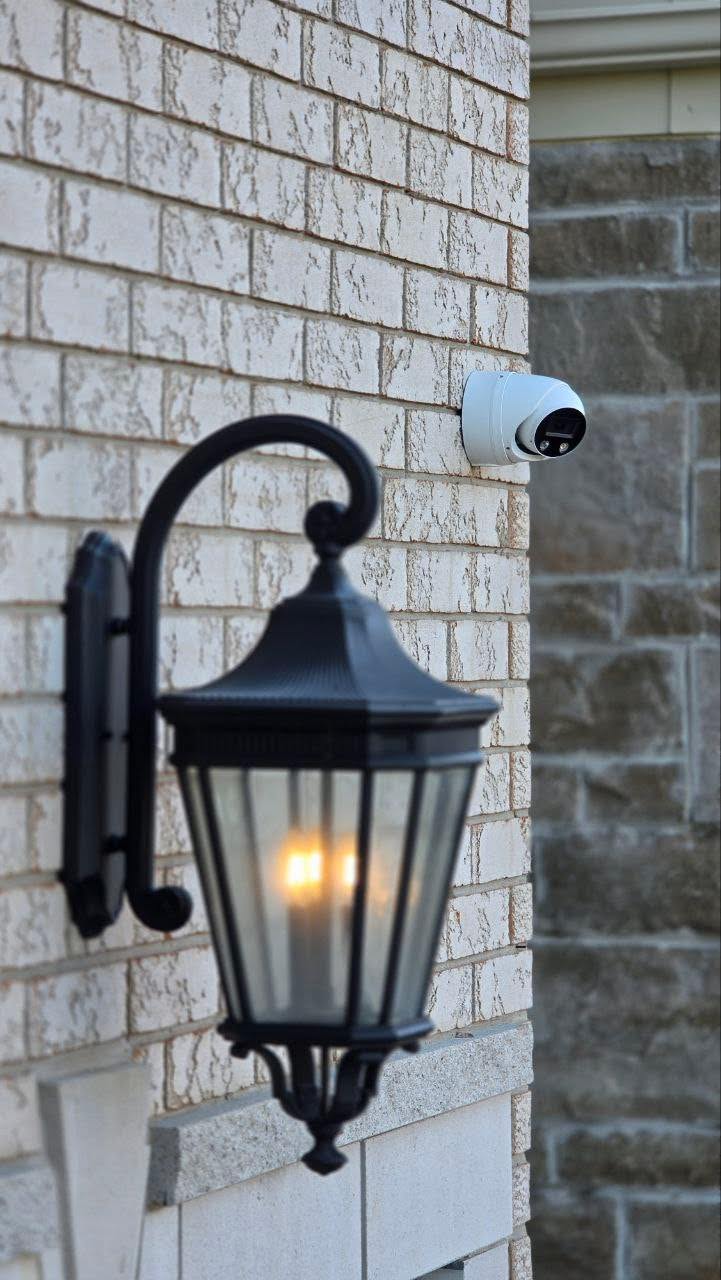 security camera and lamp on brick wall